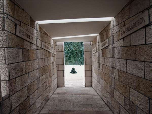 <strong>The Lonely Path</strong> The next space is a dark and lonely stone tunnel illuminated by thin slats of sunlight, while the haunting voices of Israeli children sing songs from the Holocaust. 
